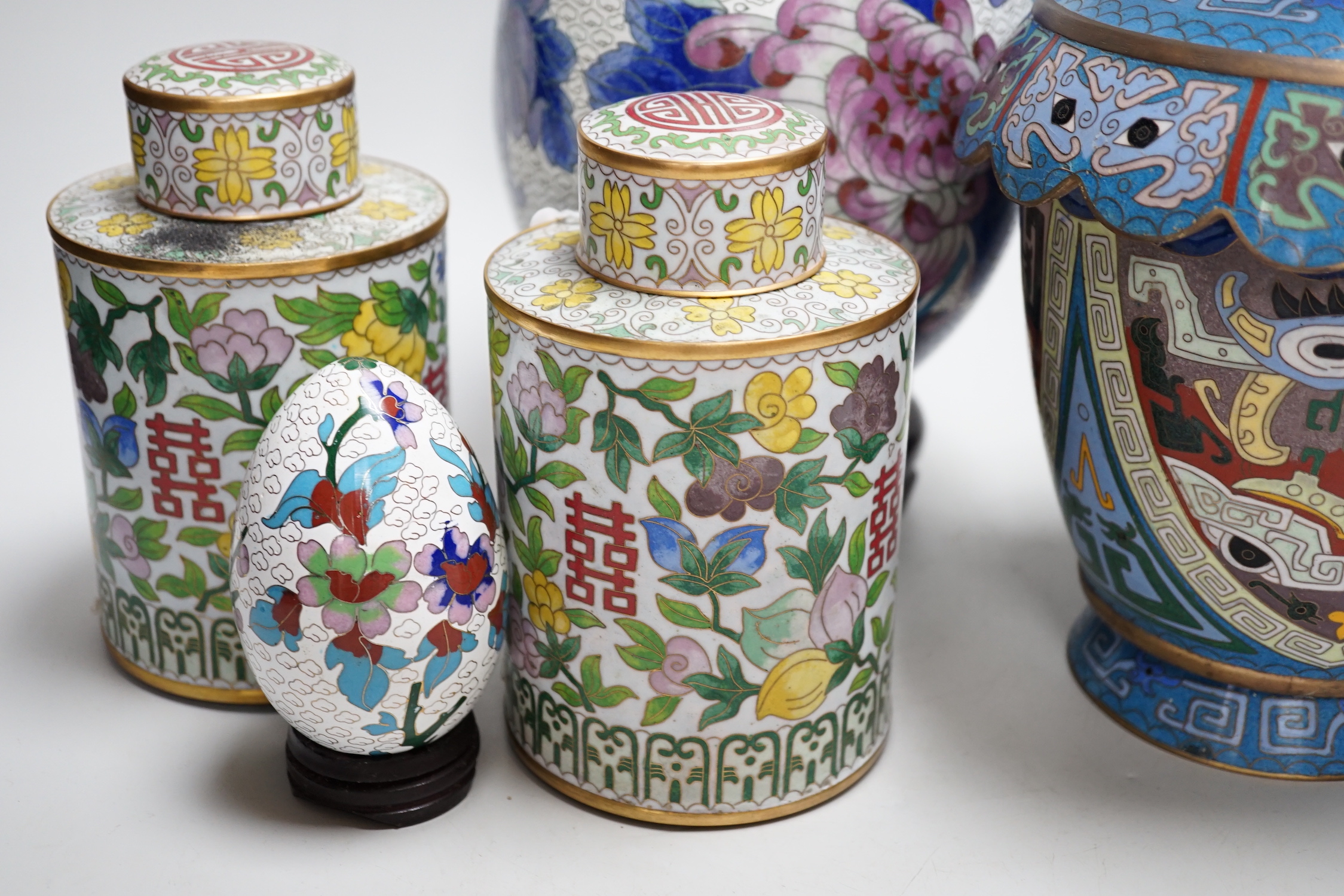 A pair of Chinese cloisonné enamel vases, a pair of canisters and covers, a large egg on stand and a small egg on stand